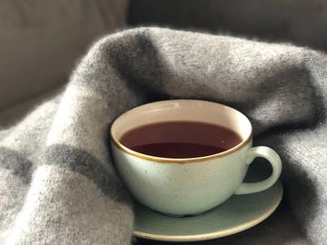 warm cup of tea with fuzzy blanket