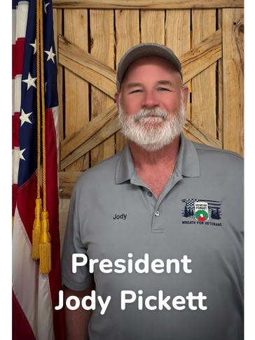 Portrait of President Jody Pickett with an American flag and wooden background.
