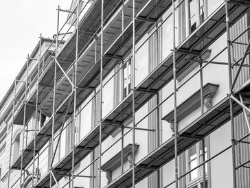 Black and white photo of a building facade covered in scaffolding