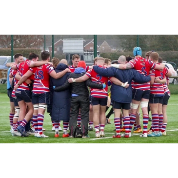 Group of Tonbridge Juddians rugby players huddling with physiotherapist Hannah perrett.