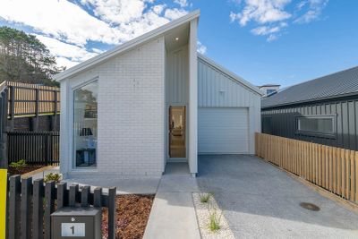 Modern house with slanted roof and white exterior.