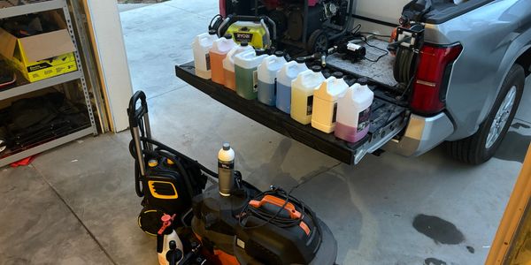 A variety of paint bottles organized on a rack in a garage.