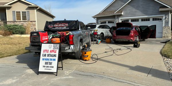 Mobile car detailing service truck with equipment and signage.