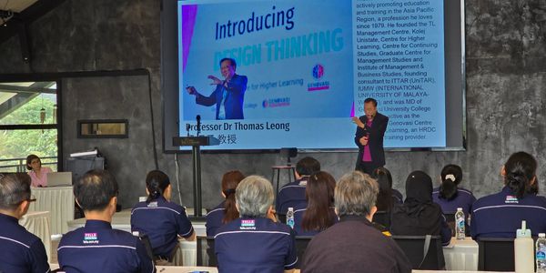 Professor Dr Thomas Leong presenting on Design Thinking to an attentive audience in a conference room.