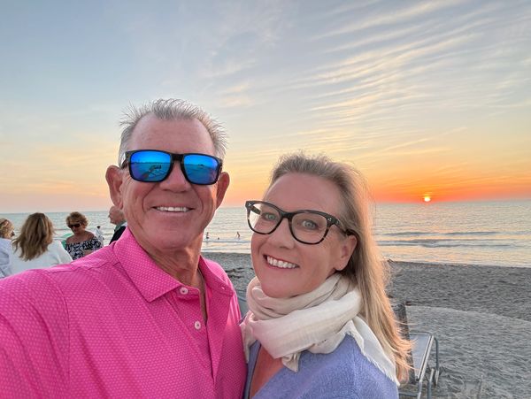 Couple smiling at the beach during sunset.