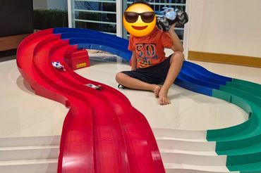 boy sitting in the middle of a tamiya mini 4wd track