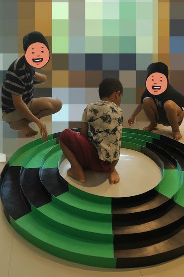 3 boys playing with a circular tamiya mini 4wd track