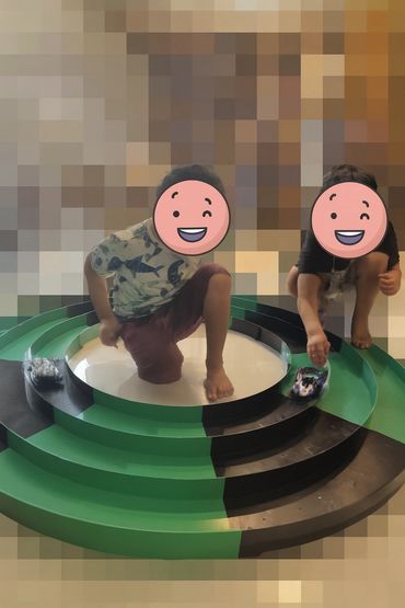 2 boys playing with a circular tamiya mini 4wd track