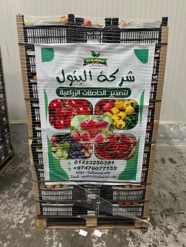 Pallet of agricultural products wrapped, featuring a banner with fruits and contact info.