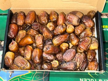 Box of fresh, plump dates with a rich brown color.
