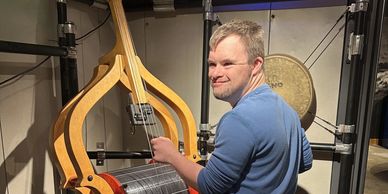 Man playing a large string instrument indoors.