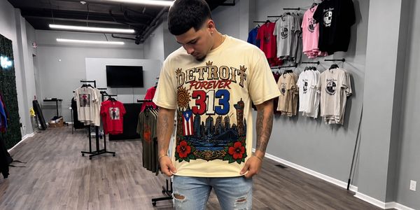Young man in a Detroit Forever t-shirt looking down in a clothing store.