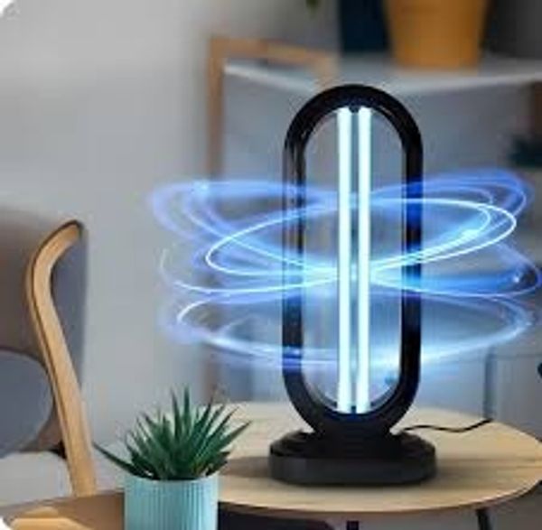 A modern UV sterilizer lamp emitting blue light on a table.
