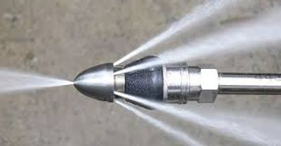 Close-up of a high-pressure water jet nozzle spraying water.