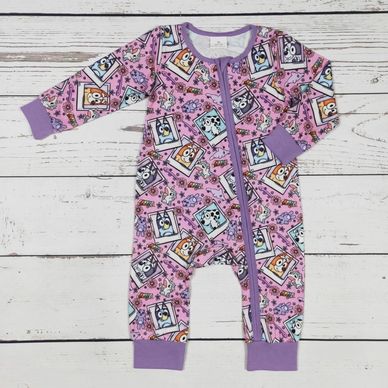 Colorful baby onesie with cartoon dog prints and purple trim.