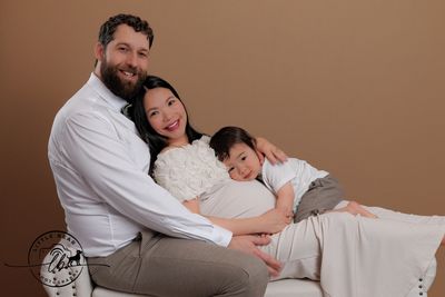 Happy family posing, embracing pregnancy joyfully.