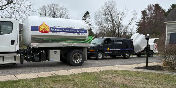 Trucks from Sgt. Smith's Drain Cleaning Services parked on a residential street.