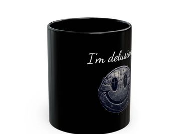 Black mug with a distressed smiley face and text saying "I'm delusional".