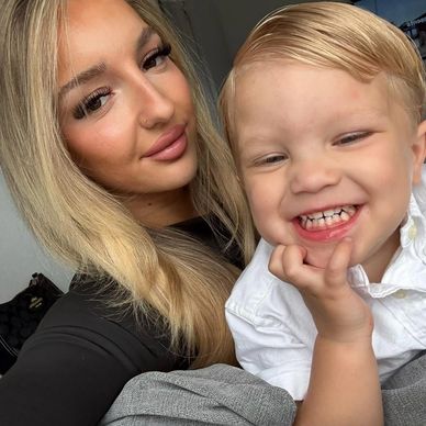 Smiling woman with blonde hair and a happy young boy in white shirt.