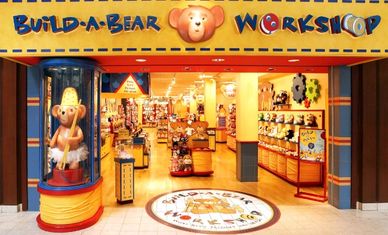 Entrance to a colorful Build-A-Bear Workshop store filled with stuffed animals.