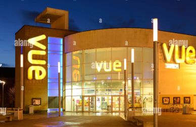 Vue cinema building illuminated at night with bright signage.