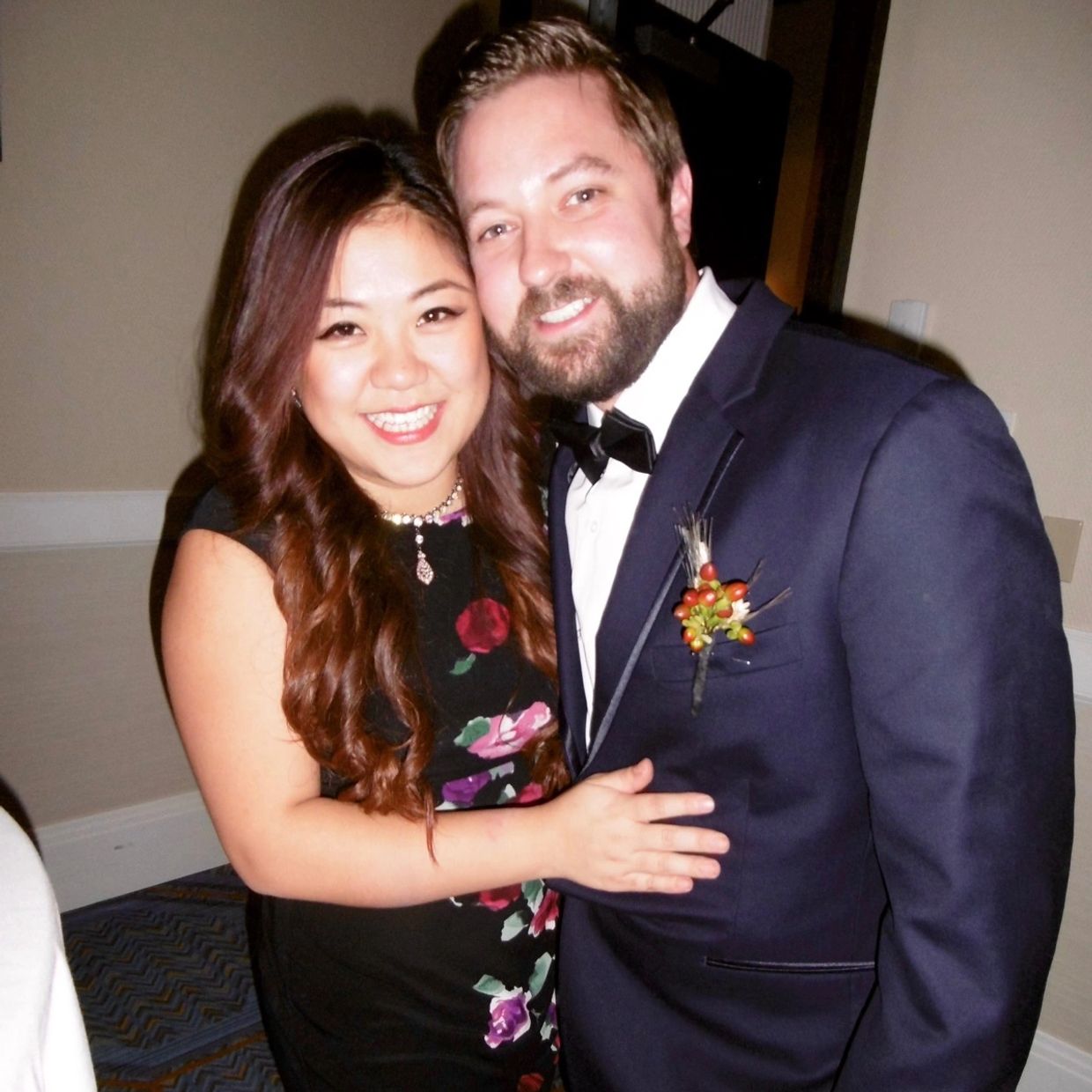 Couple smiling, dressed elegantly for an event.