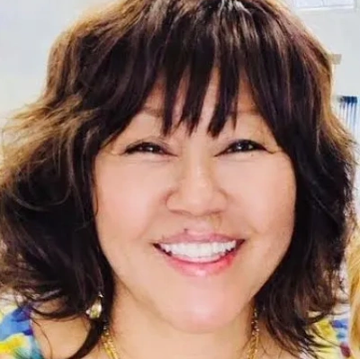 Smiling woman with short wavy hair and warm expression.
