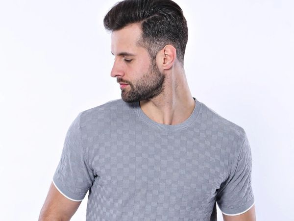 Man wearing a textured light gray short-sleeve shirt and black pants.
