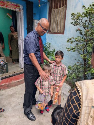 Man with two children holding toys outdoors.