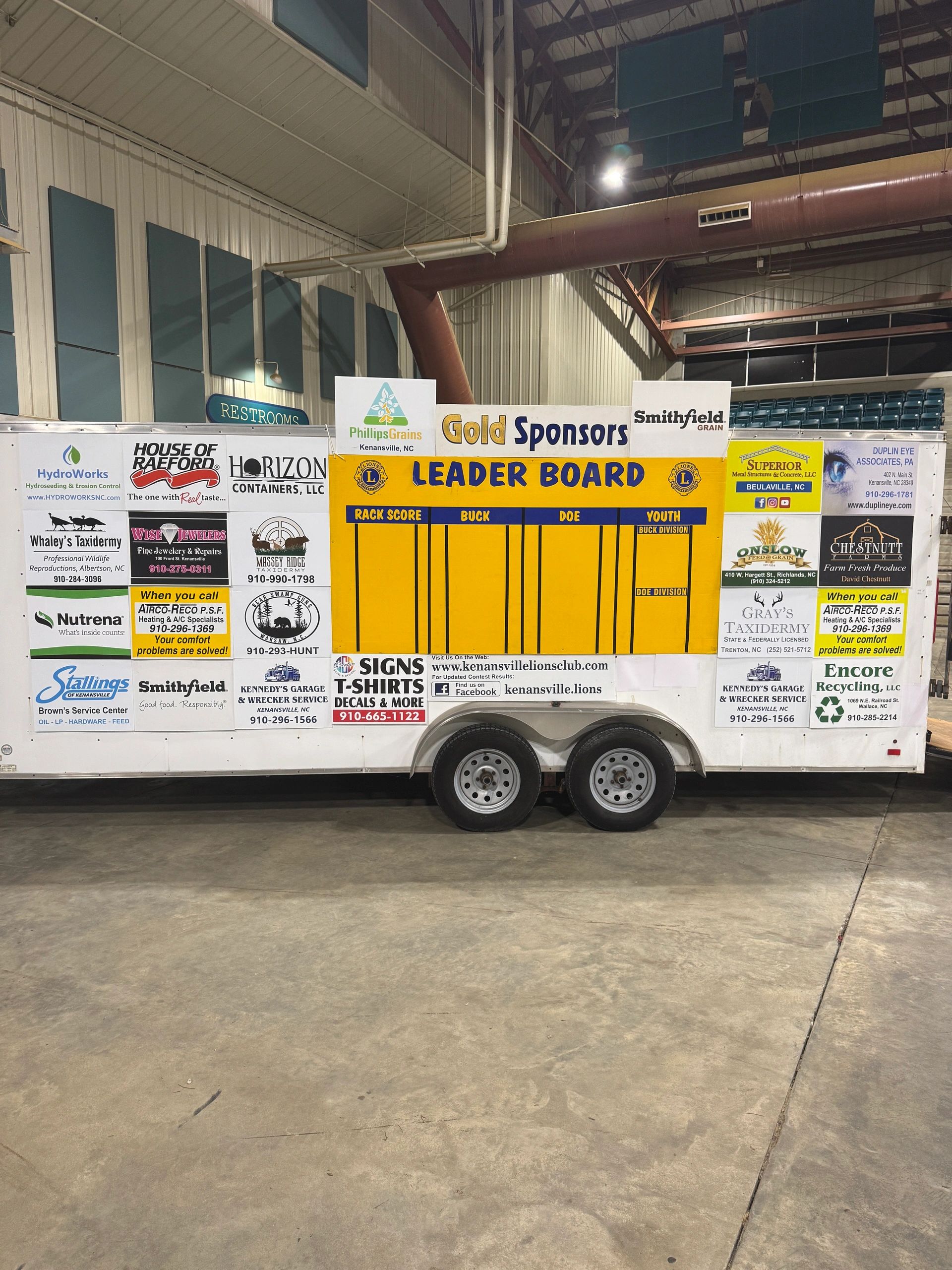 Indoor leaderboard and sponsor advertisements on a trailer.