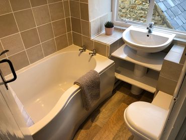 Family bathroom, P-shaped bath with electric shower overhead. Views out over the courtyard.