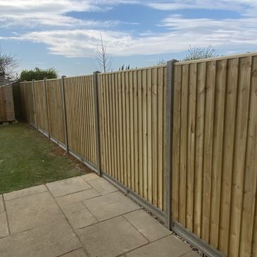 New wooden fence panels installed along a backyard patio.