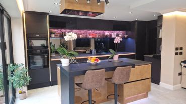 Modern kitchen with black cabinetry, island, and bar stools.