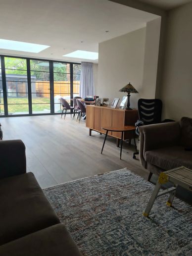 Open-plan living and dining area with rooflights and aluminium doors in a rear extension, Hounslow, 
