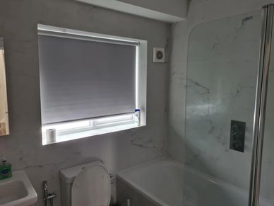 Modern family bathroom with bath, shower screen, marble-effect wall tiles and contemporary fittings 