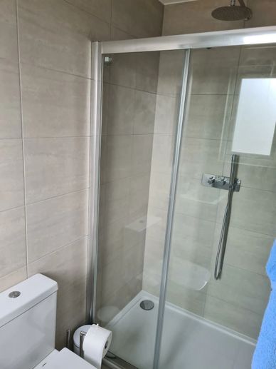 Modern loft en-suite bathroom with walk-in shower, vanity unit and large-format tiles in Hounslow, W