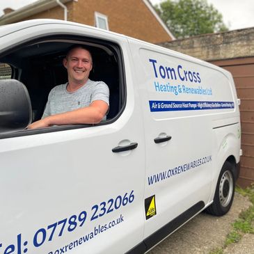 Man smiling in a heating and renewables service van.