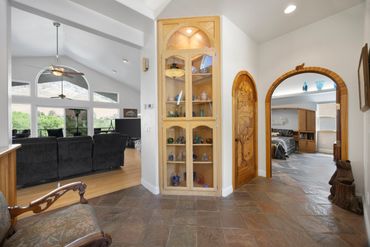 Spacious home interior with arched doorways and built-in display cabinet.