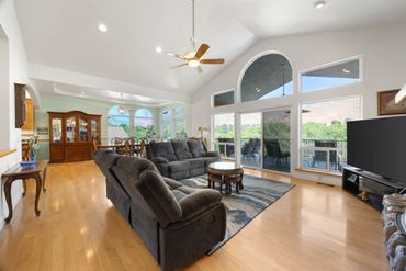 Spacious living room with large windows and comfortable seating.