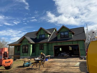 House under construction with workers and equipment.