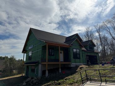 House under construction with green sheathing.