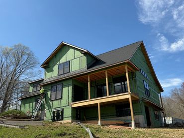 House under construction with green sheathing.