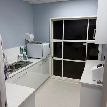 Clean, compact medical or laboratory workspace with white cabinets and equipment.