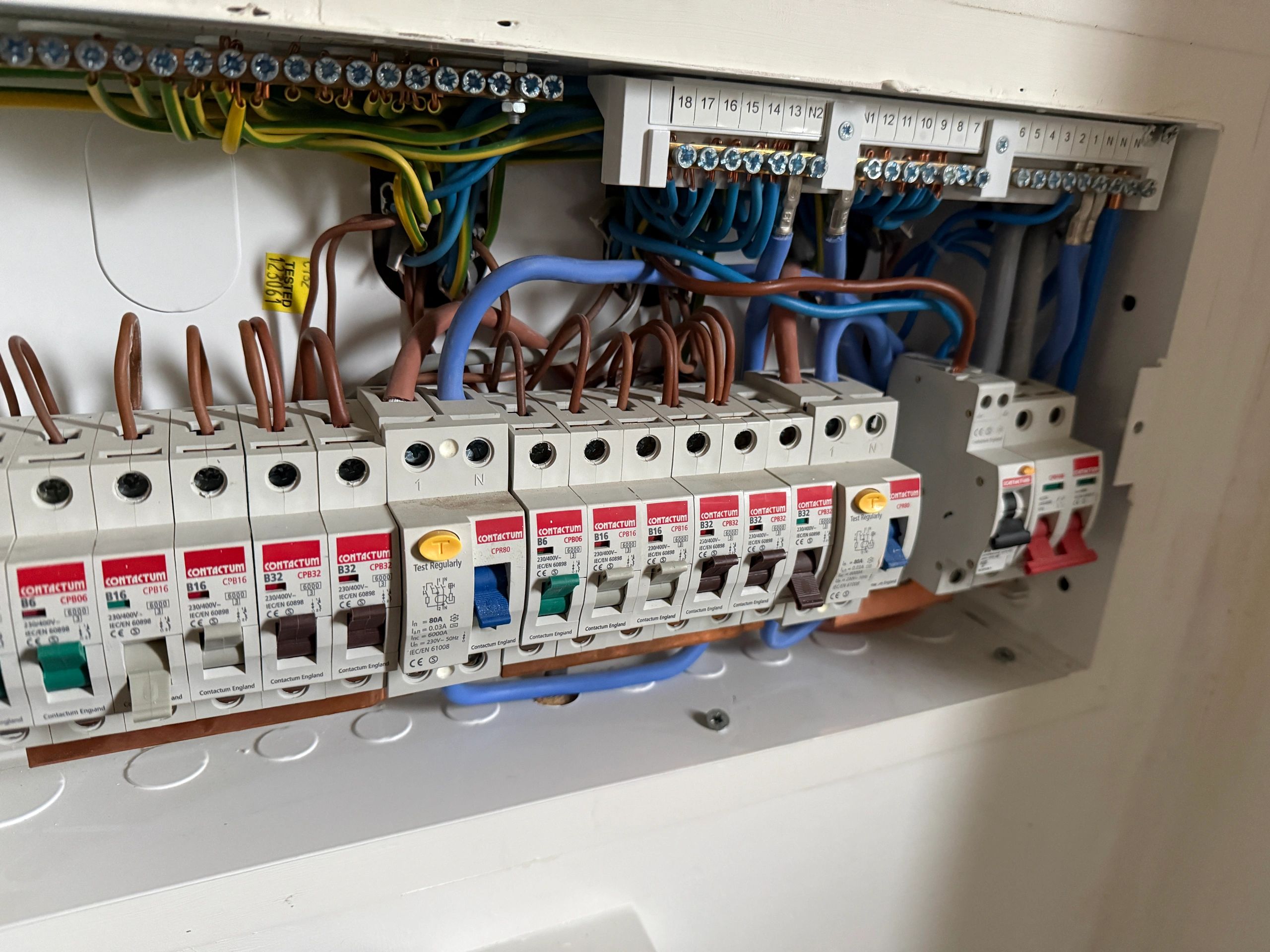 Close-up of an electrical circuit breaker panel with labeled switches and wiring.