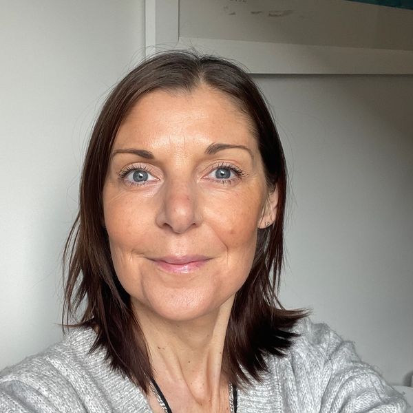 Woman with short brown hair and blue eyes smiling.