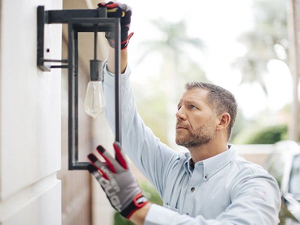 A man install exterior light, a handyman putting a light in. 