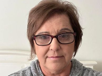 Portrait of a middle-aged woman with glasses.