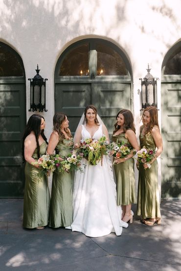 Bride with bridesmaids in olive green dresses.
