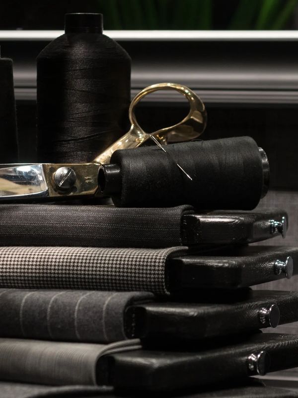 Sewing thread spools, scissors, and folded fabric neatly stacked.