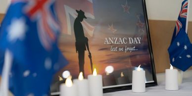 ANZAC Day remembrance with candles and flags honoring fallen soldiers.